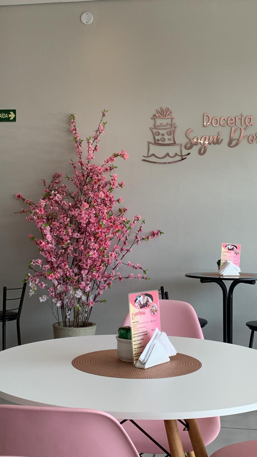 Interior da loja com cerejeira e logo na parede