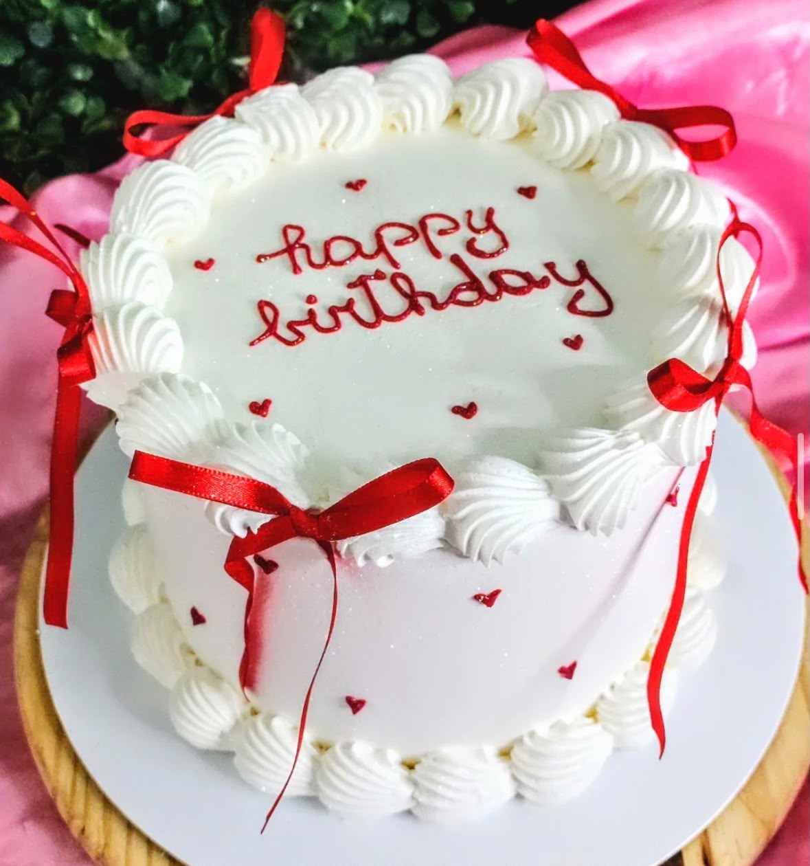 Bolo branco com laços vermelhos e Happy Birthday